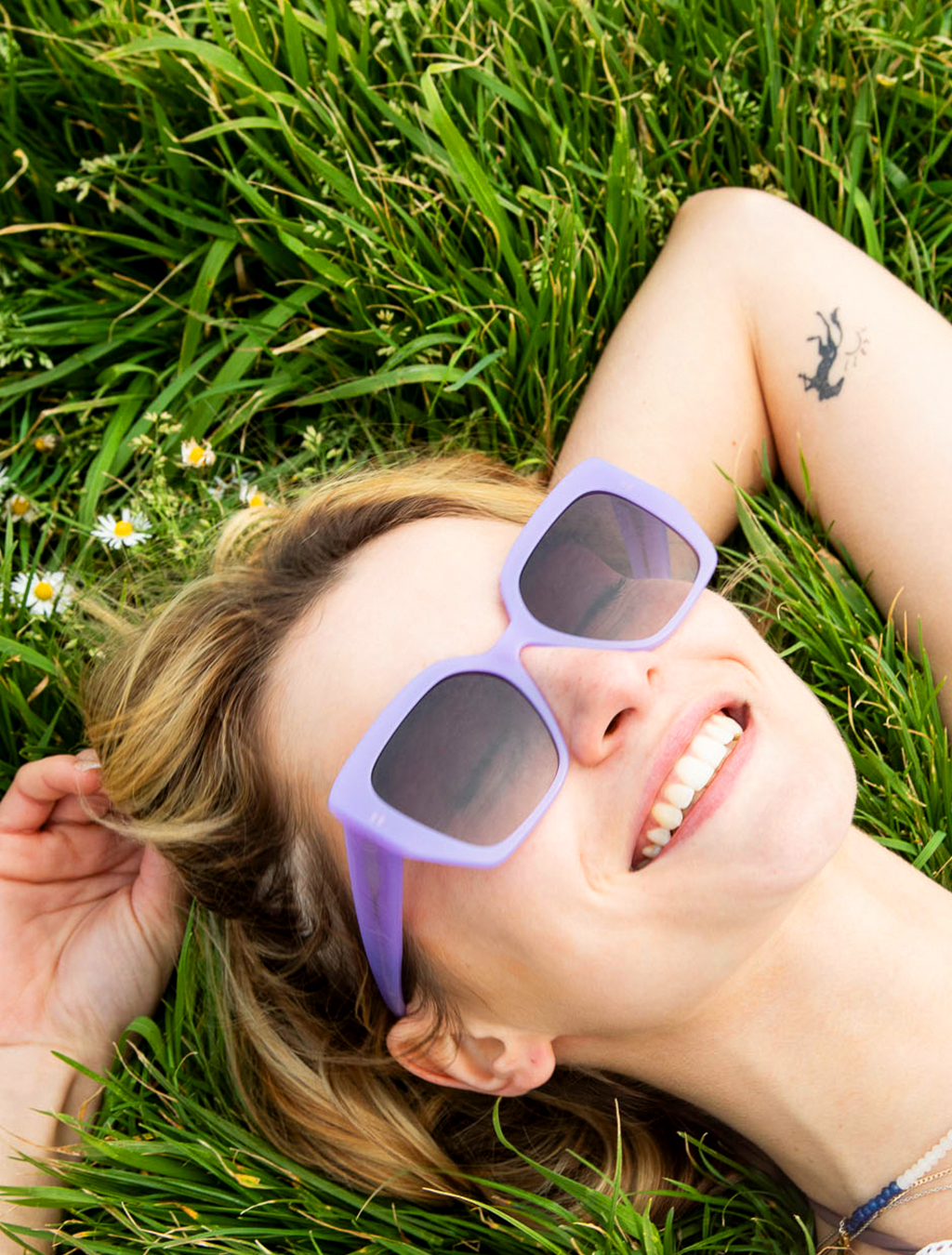 Woman wearing bold colourful eco acetate sunglasses by Zoë de Pass, female-founded eyewear maker