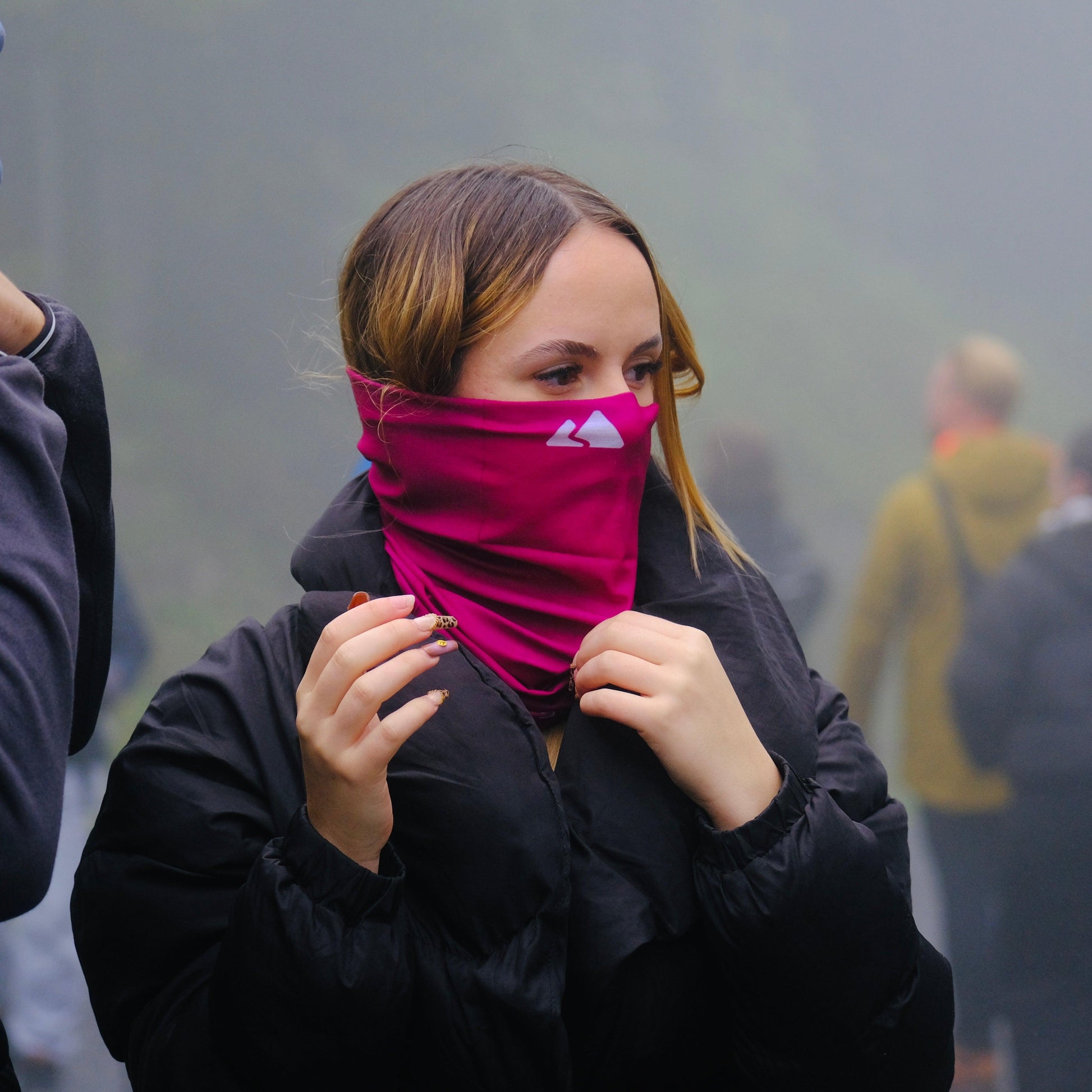 Person wearing a pink face covering with a logo in an urban setting from Stride brand on Sostter