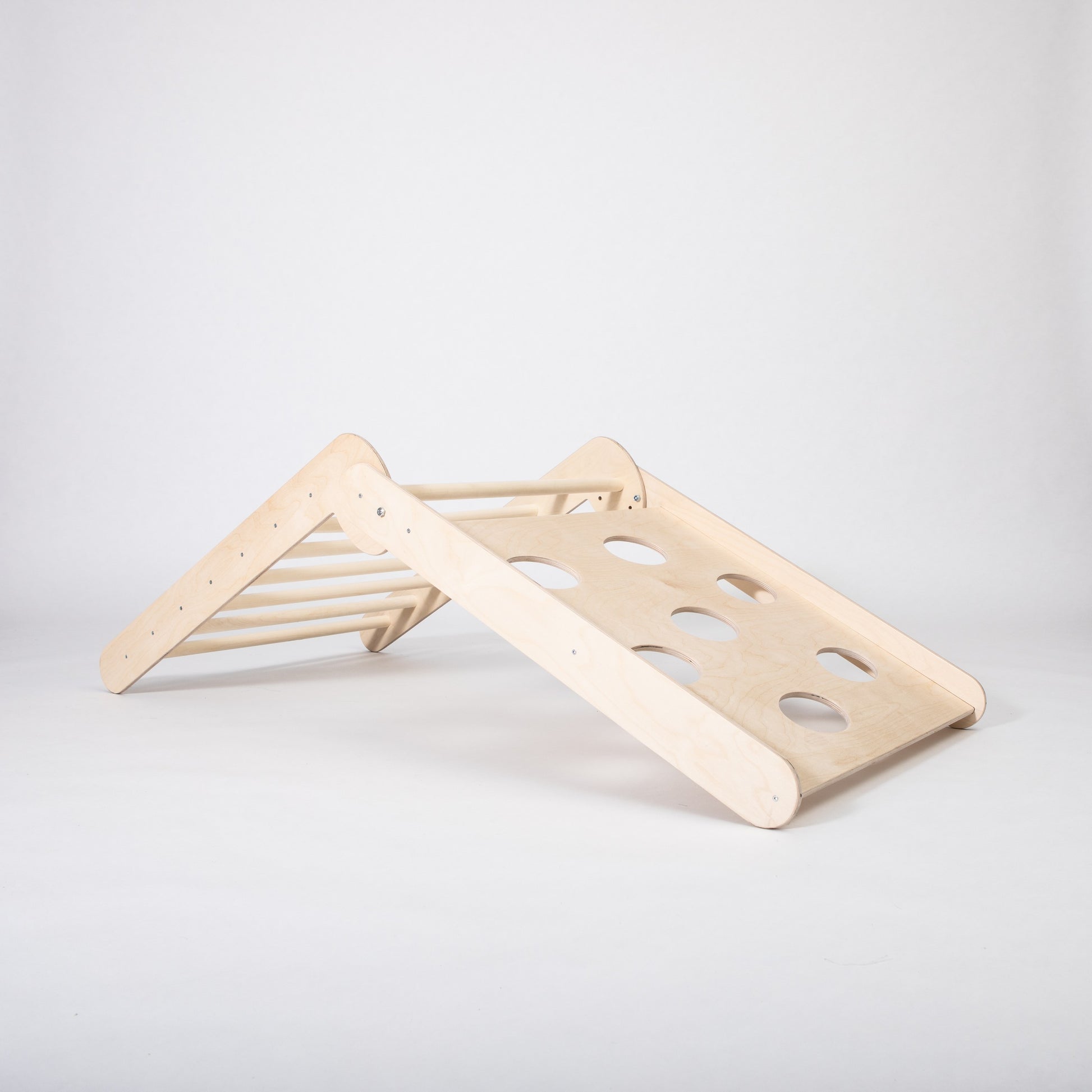 toddler climbing foldable montessori triangle in a sunlit playroom with soft rugs nearby