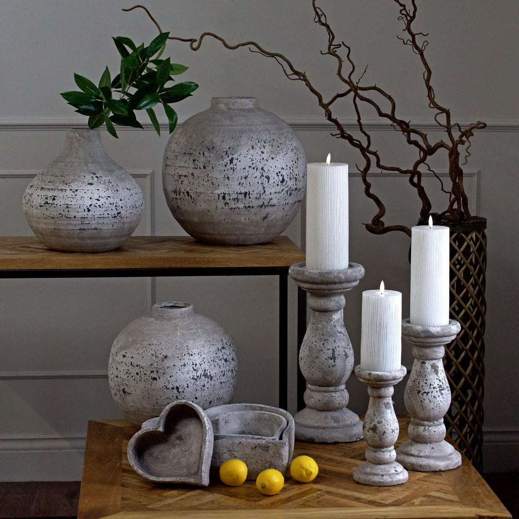 Handcrafted ceramic candle holder with natural stone texture in minimalist design, creating warm ambient lighting. by sostter at brixbailey.com