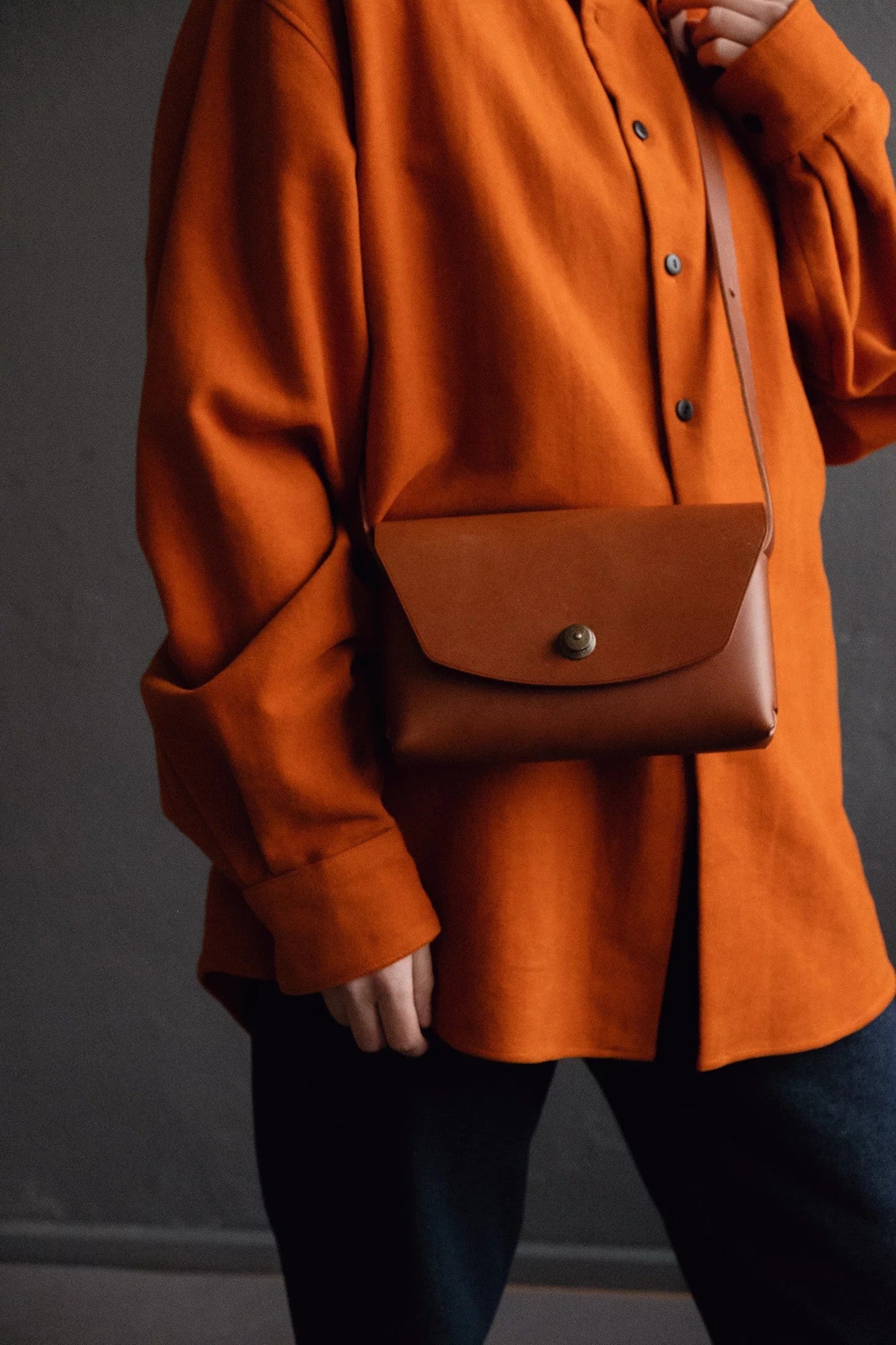 bold close-up of a rustic handmade leather clutch bag with rich texture and confident style