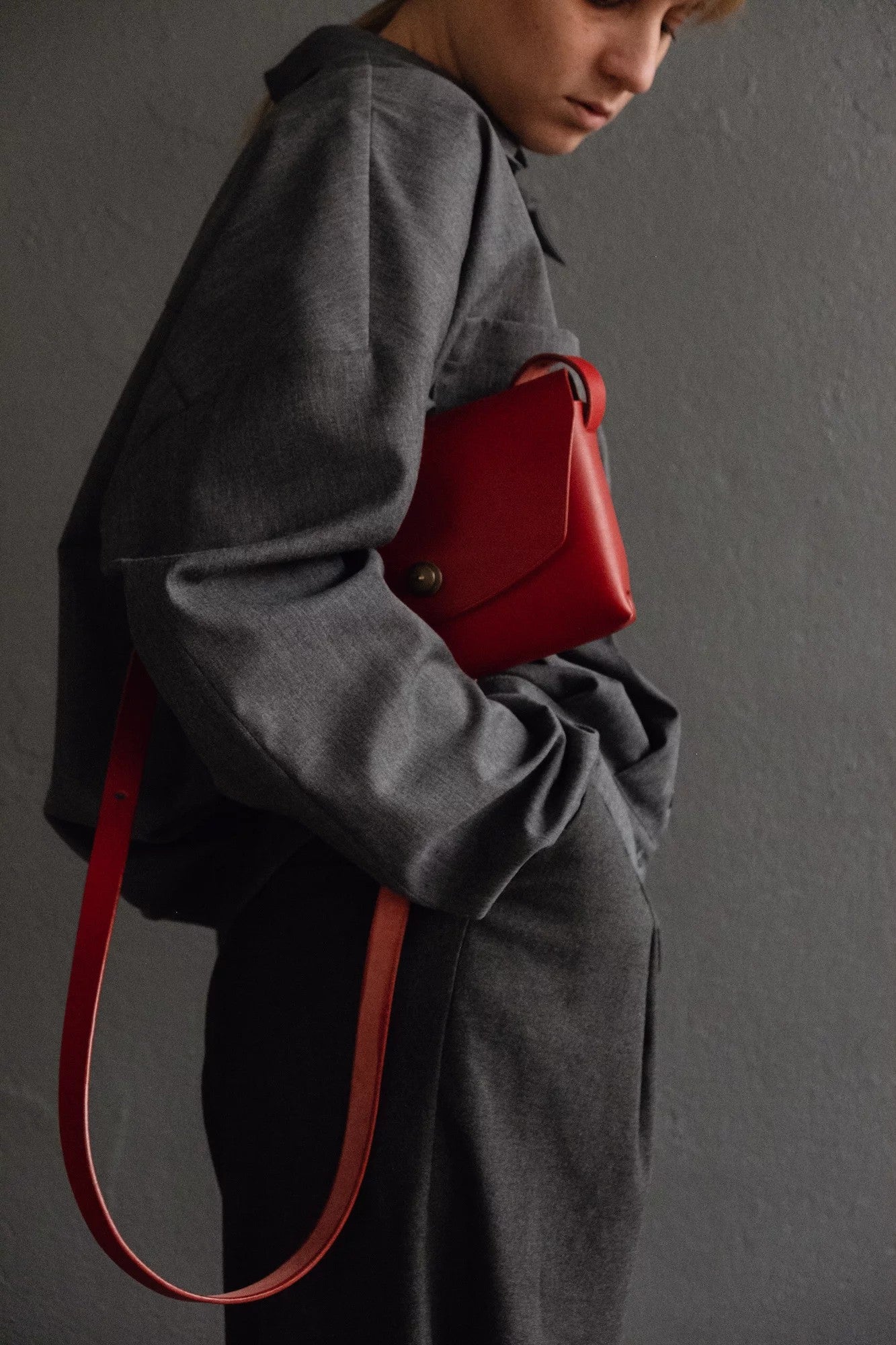 a playful close-up of the vibrant red handmade leather clutch bag on a fun, colorful background