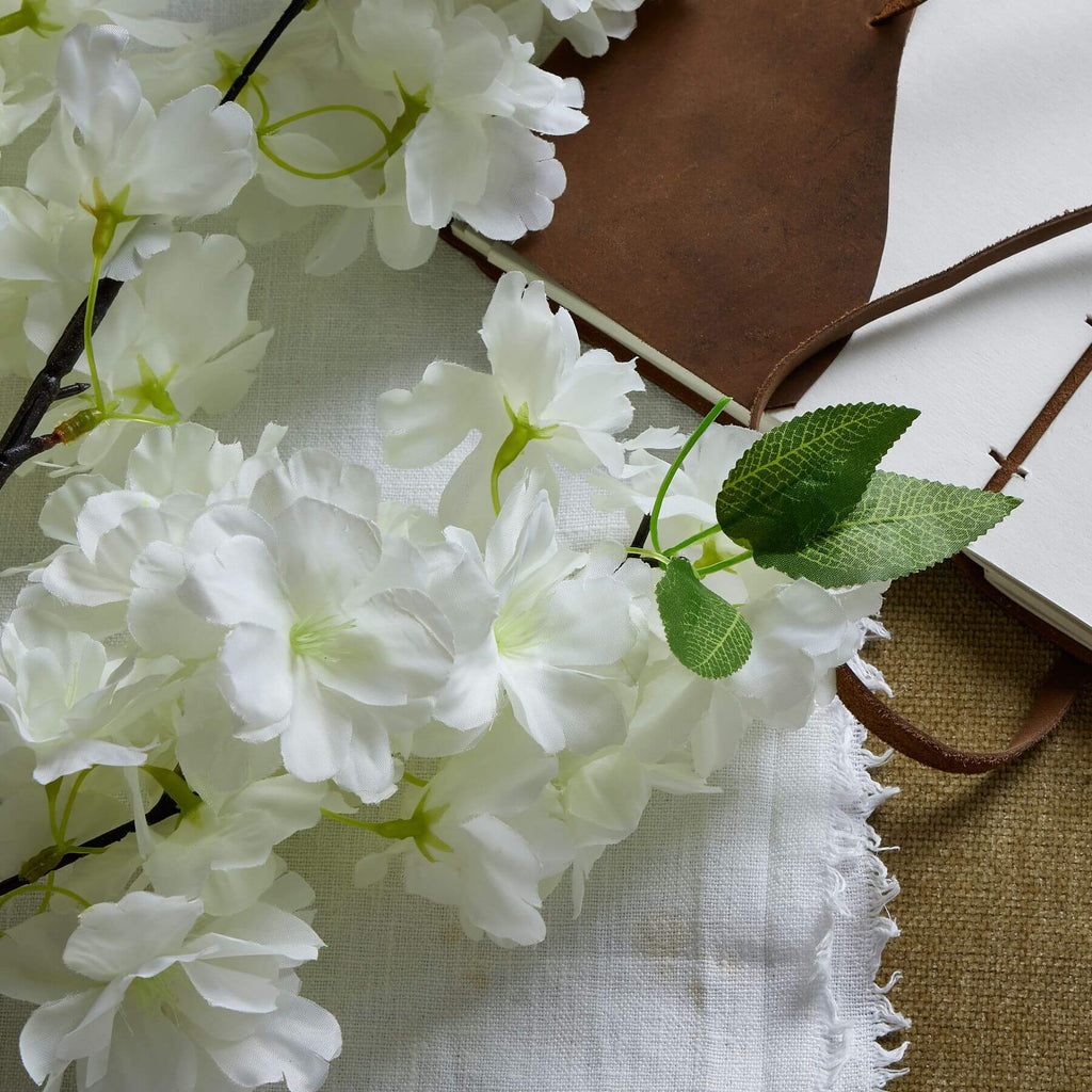 White artificial cherry blossom stem with cascading petals, 100 cm tall, perfect for spring floral arrangements.by Sostter at brixbailey.com