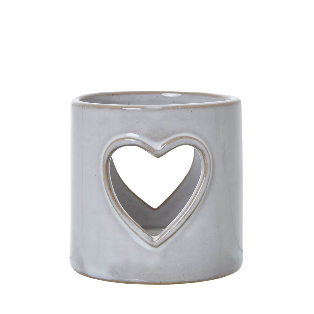 White ceramic tealight holder with heart cutouts, casting romantic light patterns, perfect for home decor and ambiance. by RoomLondon at brixbailey.com