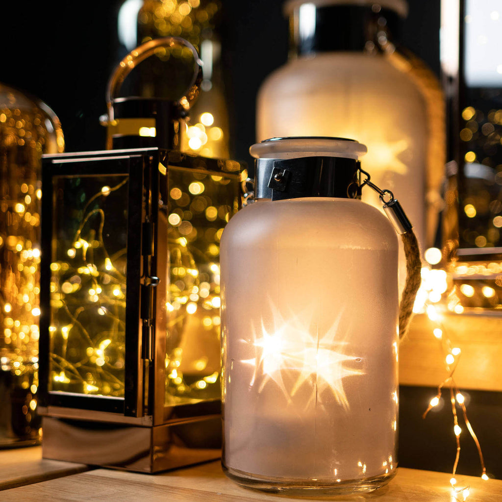 Frosted grey glass lantern with rope handle, glowing LED lights creating starlight effect, perfect for indoor or outdoor decor. by RoomLondon at brixbailey.com