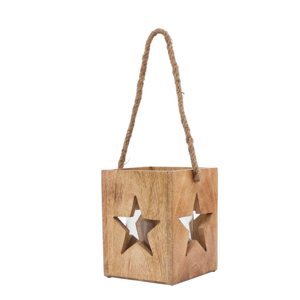 Handcrafted wooden star tealight holder with intricate celestial design, casting warm boho shadows on natural wood. by RoomLondon at brixbailey.com