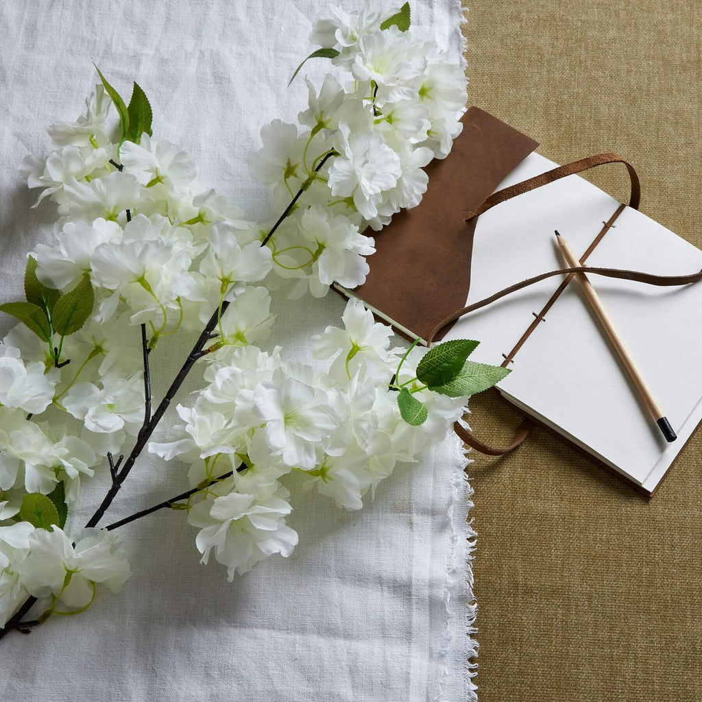 White plastic cherry blossom stem with cascading petals, 100 cm tall, perfect for spring floral arrangements.by Sostter at brixbailey.com