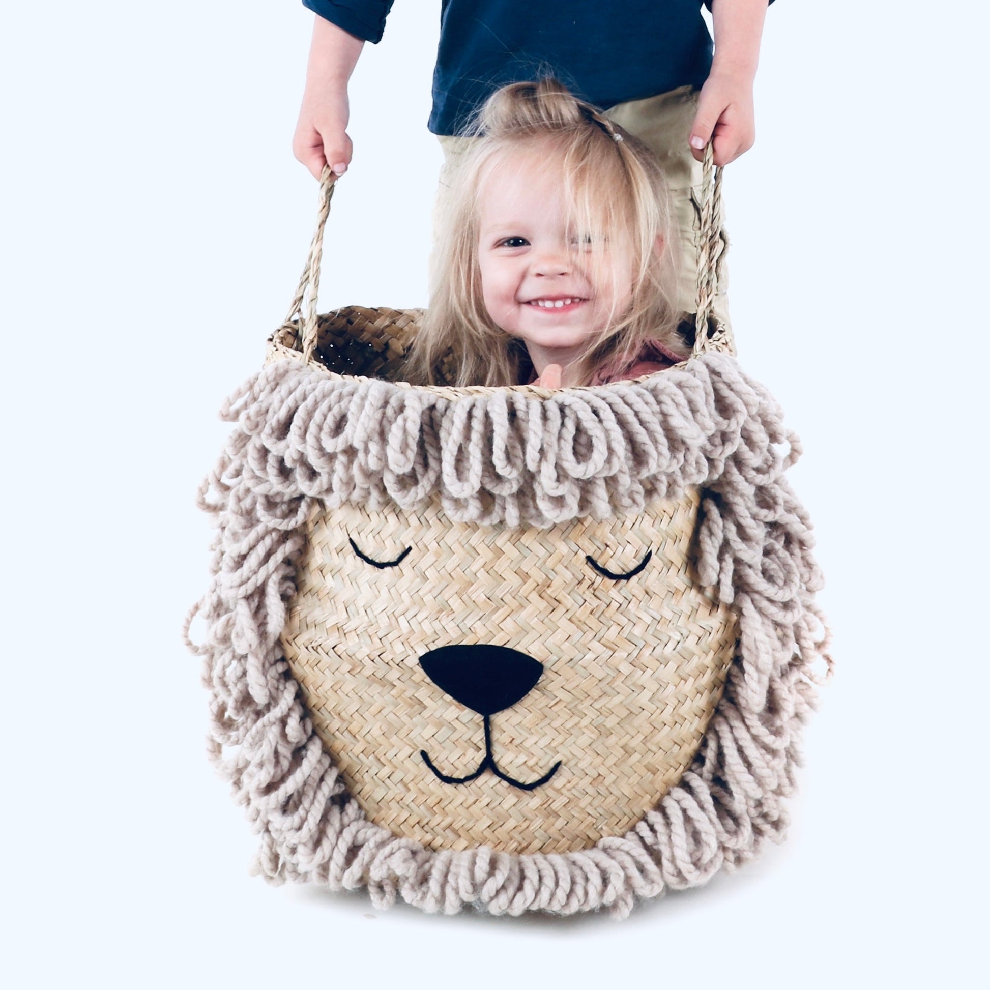 Child holding a lion-shaped woven basket with a plain background on Sostter