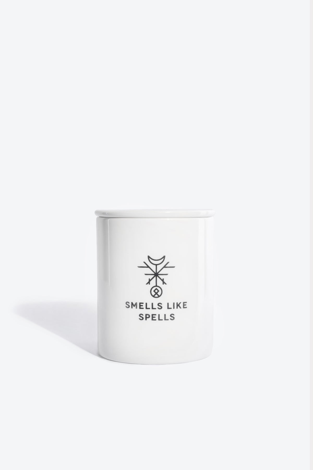 a softly lit justice tarot candle glowing on a wooden altar, its porcelain vessel radiating a comforting warmth
