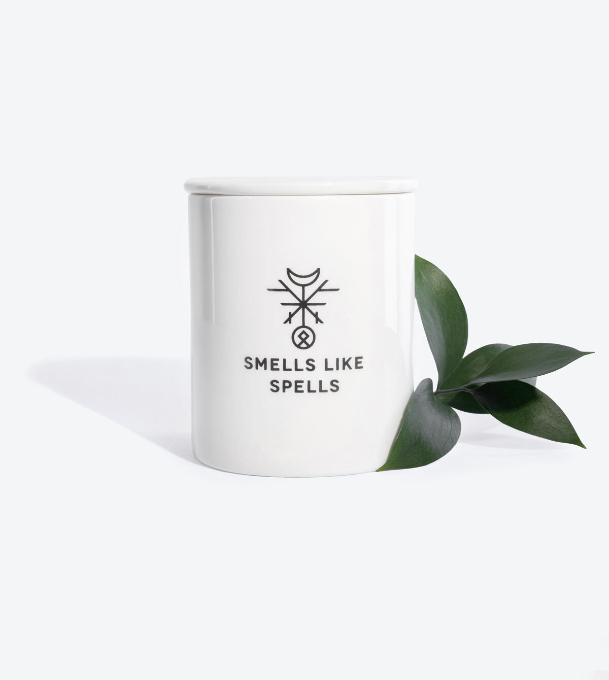 elegant handmade porcelain emperor tarot candle with cedar and saffron, glowing softly in refined light