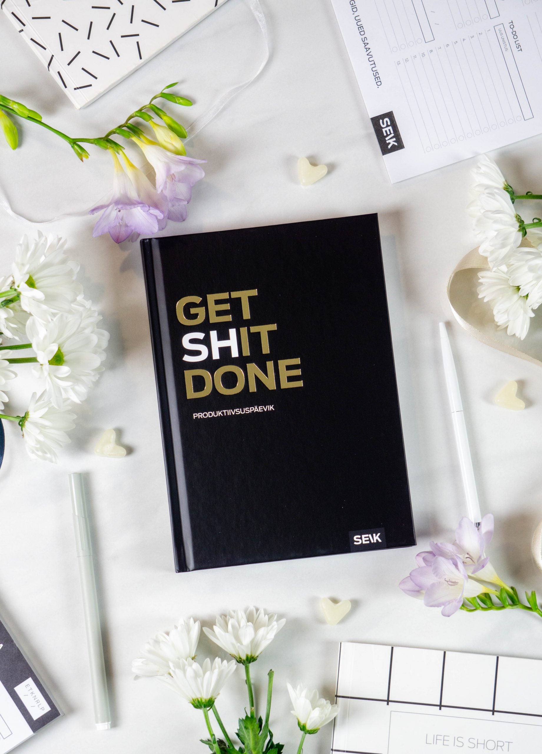 a bold close-up of the productivity planner on a dark desk with dramatic lighting