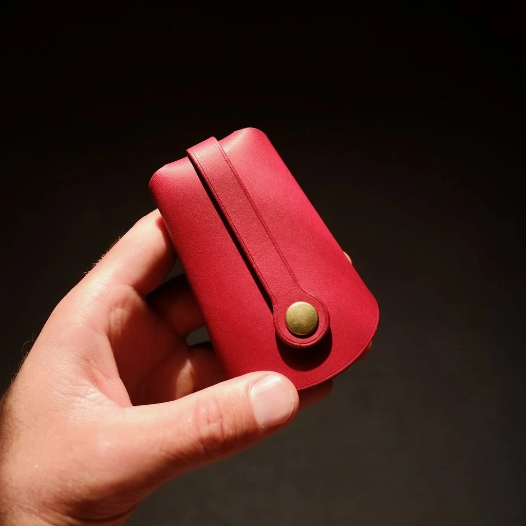playful close-up of a vibrant red leather keyholder with keys fanned out