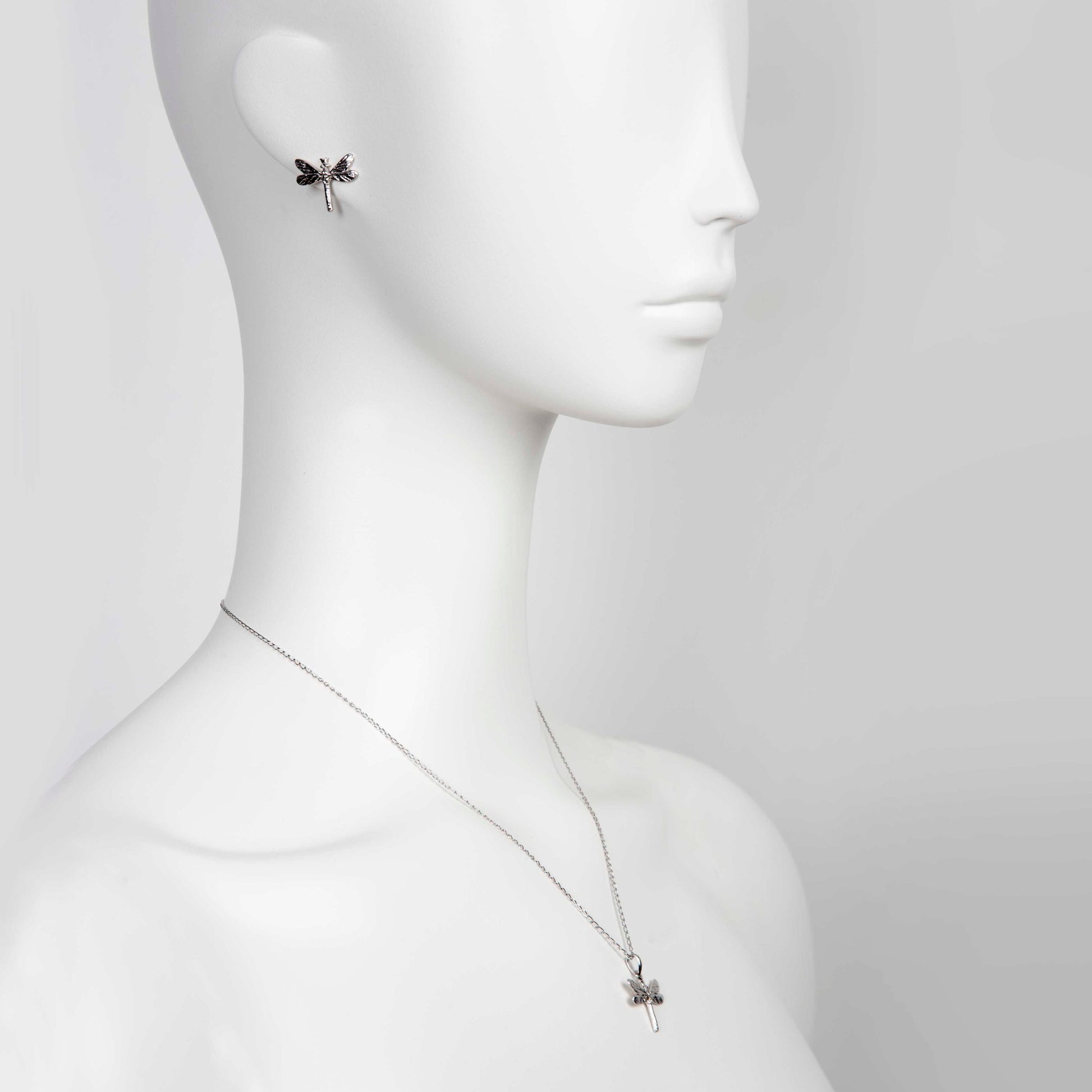 bold dark dragonfly earrings in dramatic close-up on a model with confident gaze