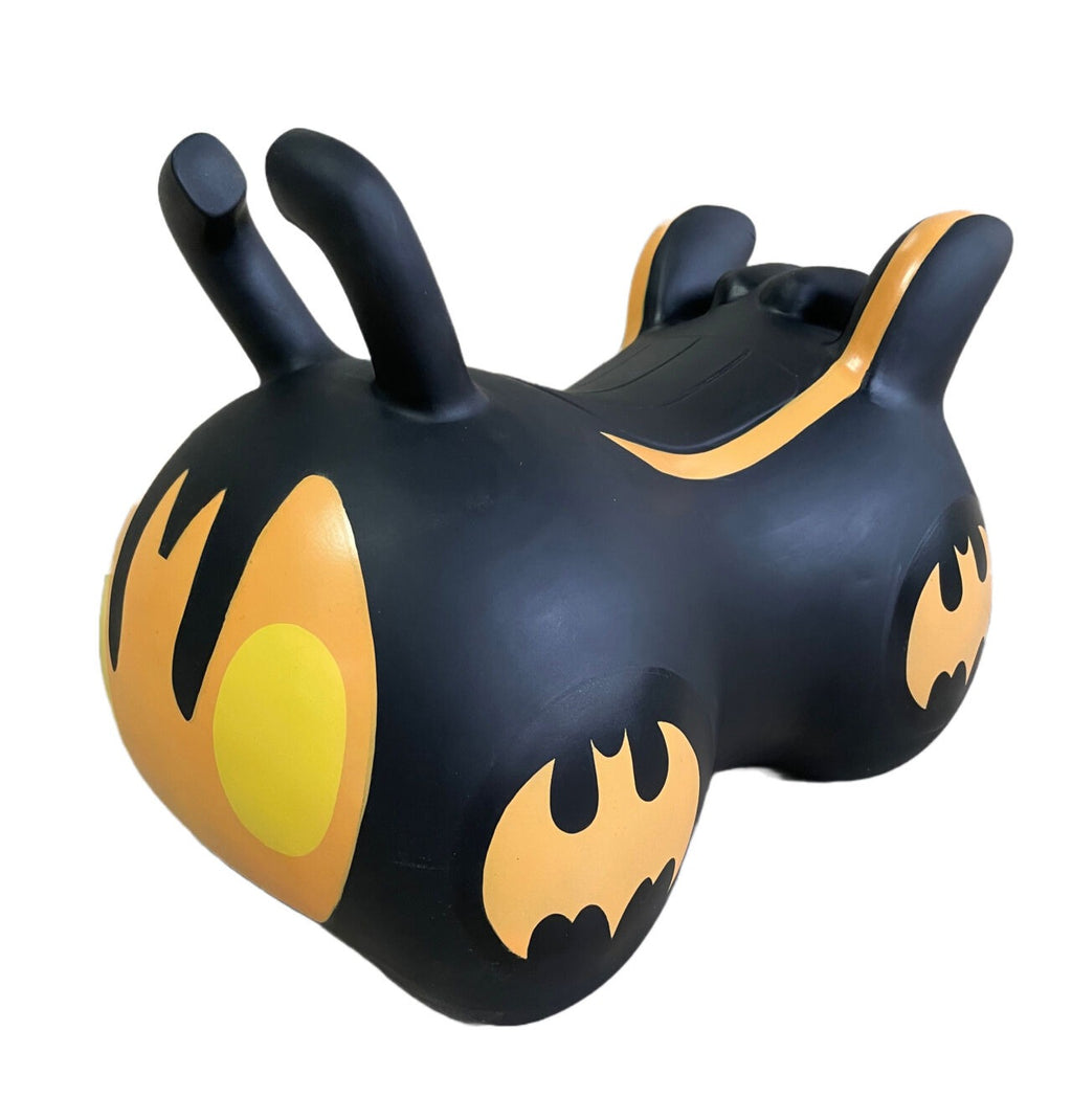 a soft-focus shot of a child gently holding the batmobile jumpy hopper in a cozy nursery