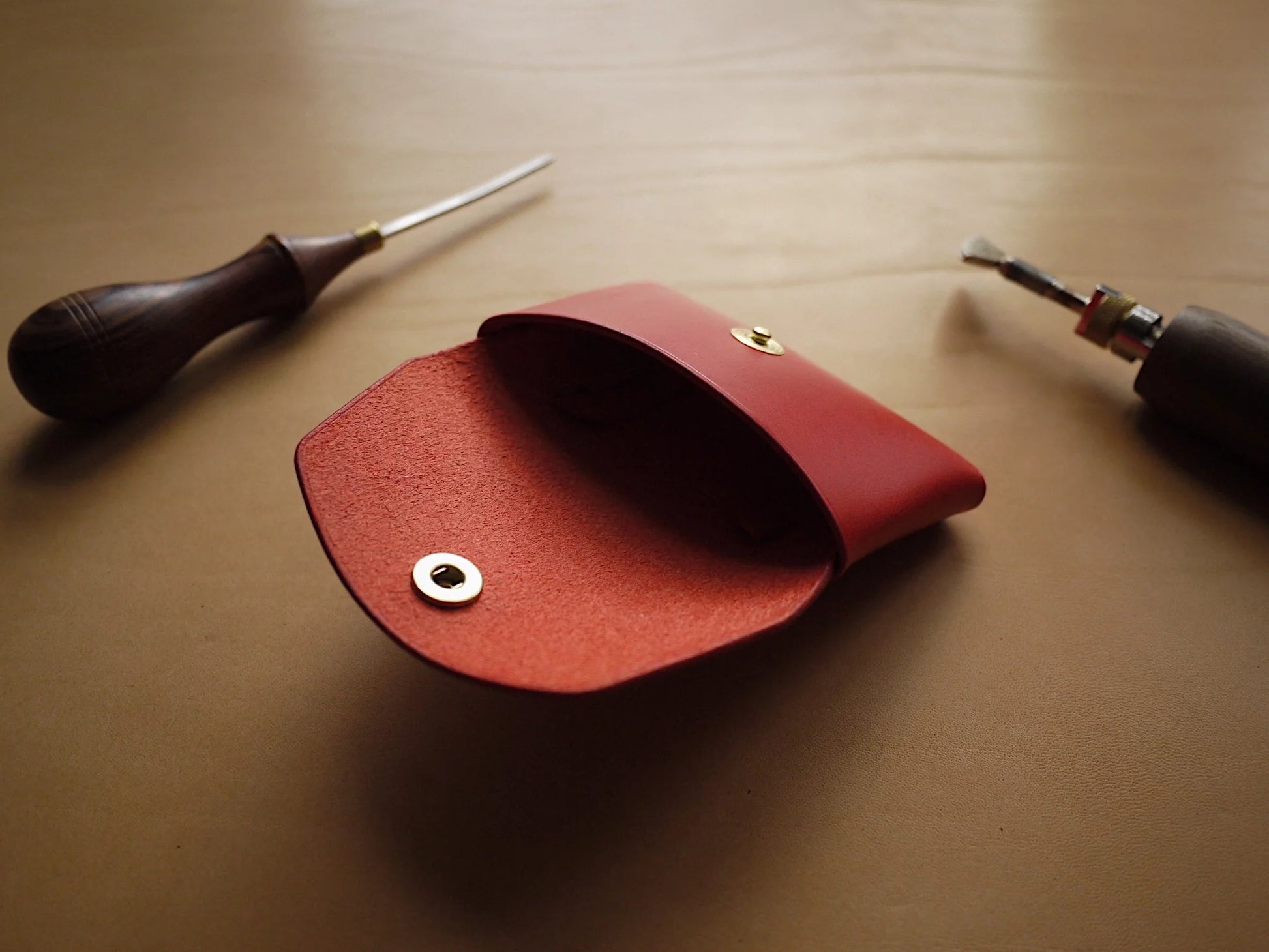 playful close-up of a vibrant red handmade leather wallet on a fun adventure