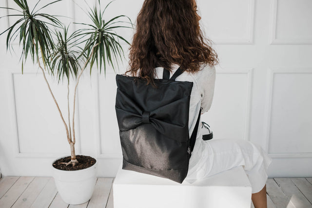 Chic Black Bow Backpack – Stylish & Waterproof for All Occasions by Muni at www.brixbailey.com