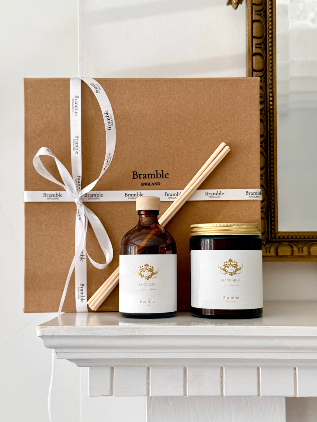 Bramble brand products including a bottle, jar, and box on a white surface with a decorative mirror in the background.