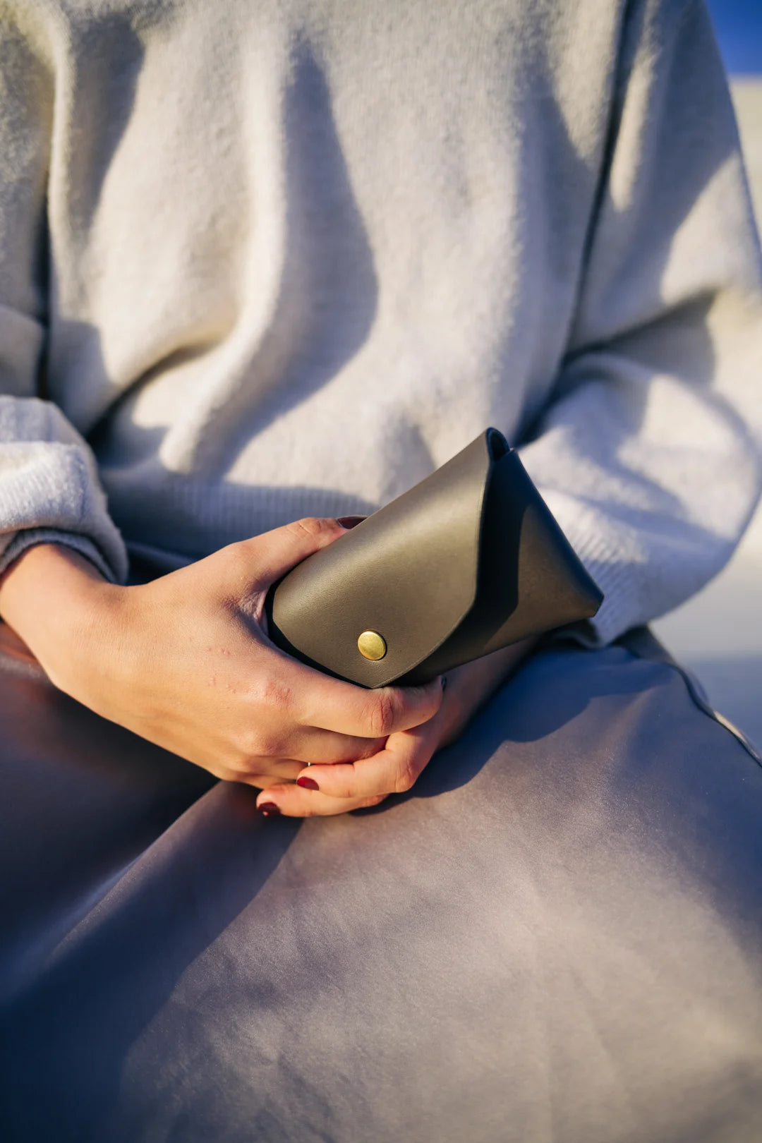 a bold close-up of a sleek black leather sunglasses case on a dark background