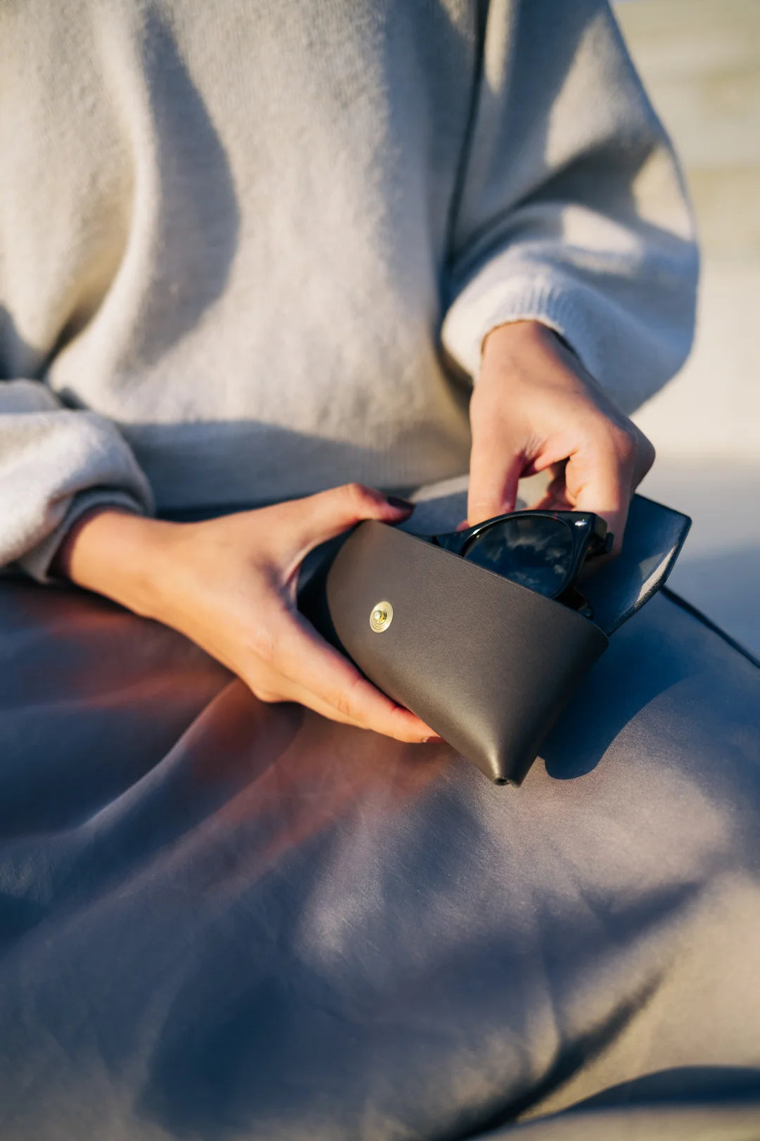 elegant black leather sunglasses case resting on a marble surface, showcasing its refined estonian craftsmanship