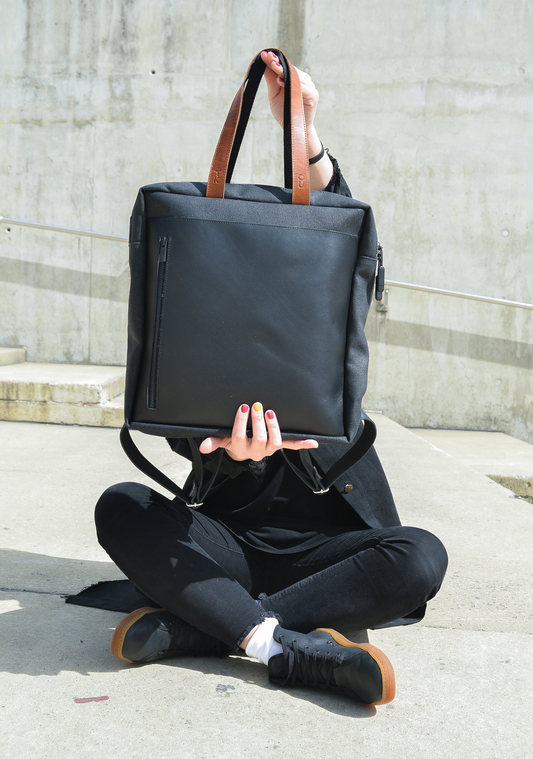 bold purple and black stockholm backpack with leather accents in dramatic studio lighting