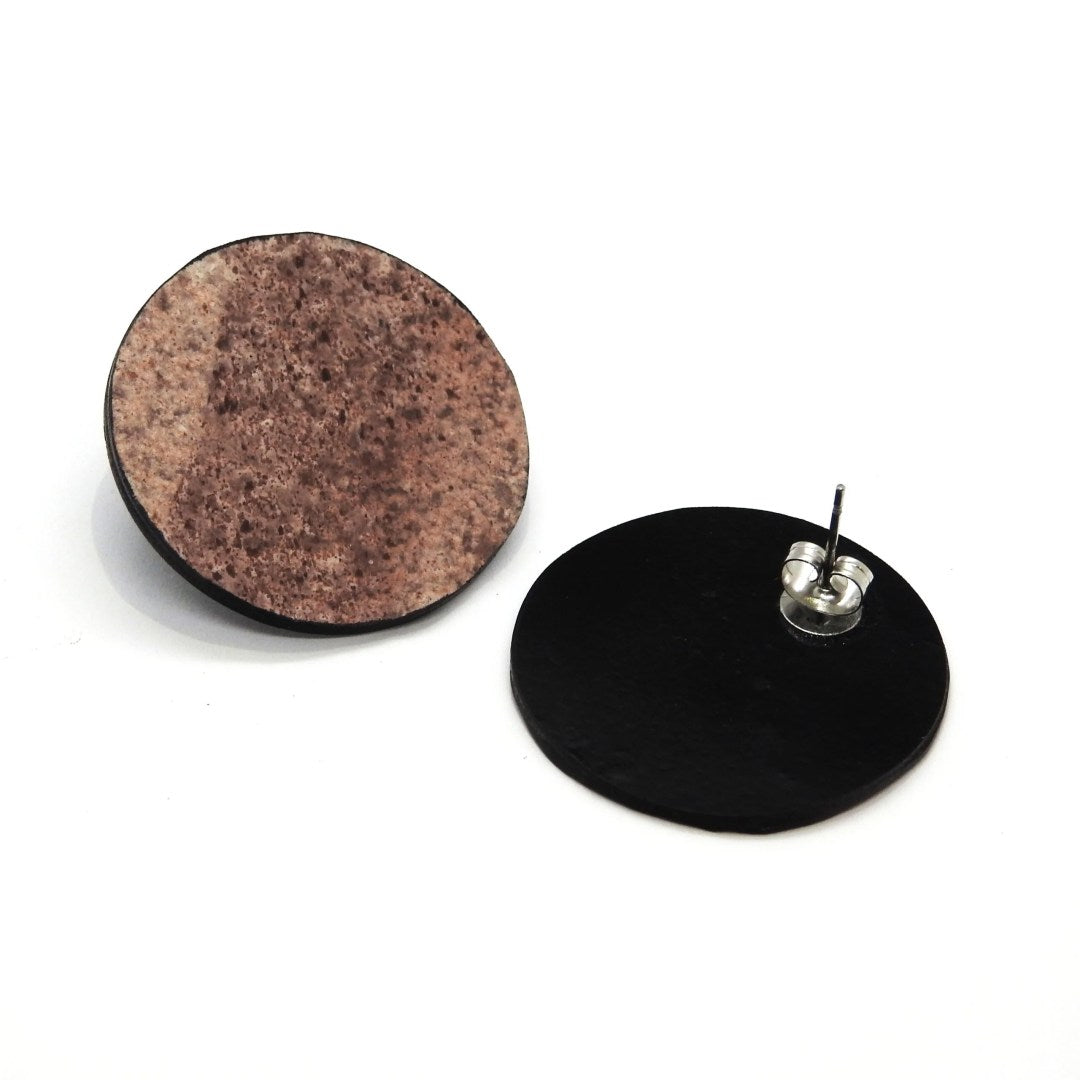 bold red canyon orbit earrings in dramatic studio lighting showcasing the raw slate and marble texture