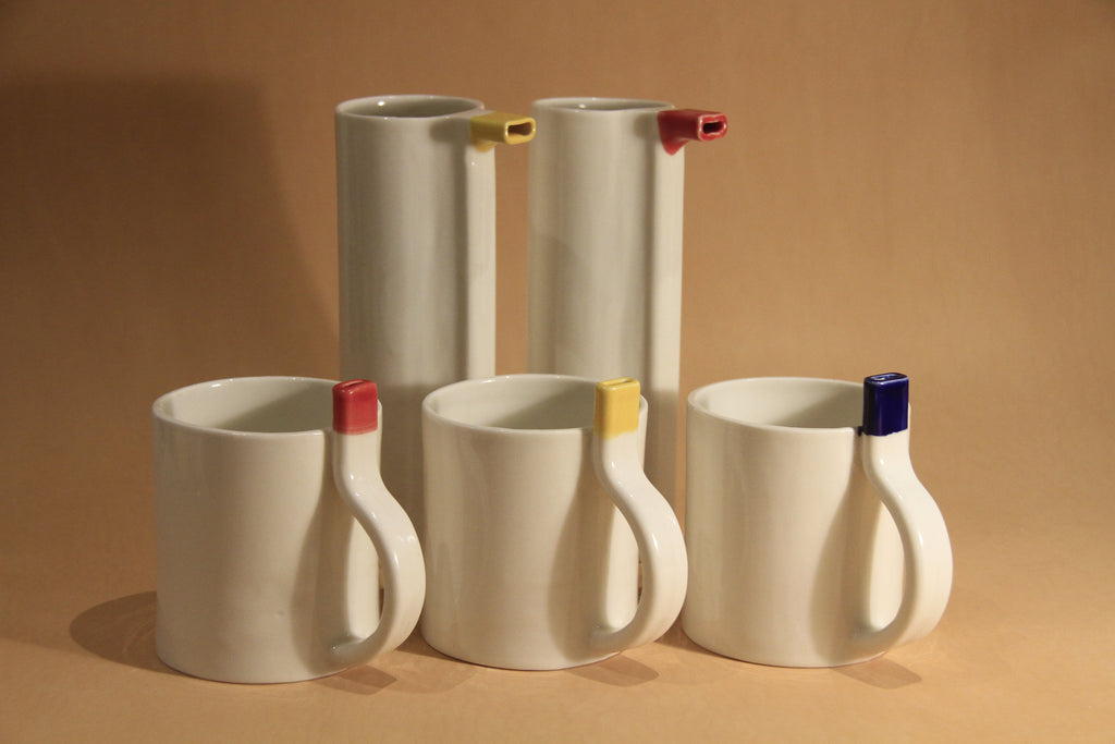 Set of ceramic mugs with colorful handles on a brown background