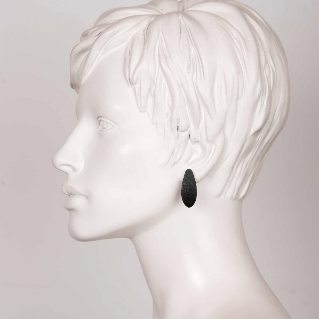 bold close-up of elegant mini blackcurrant earrings with cosmic dust shimmer on a dark background