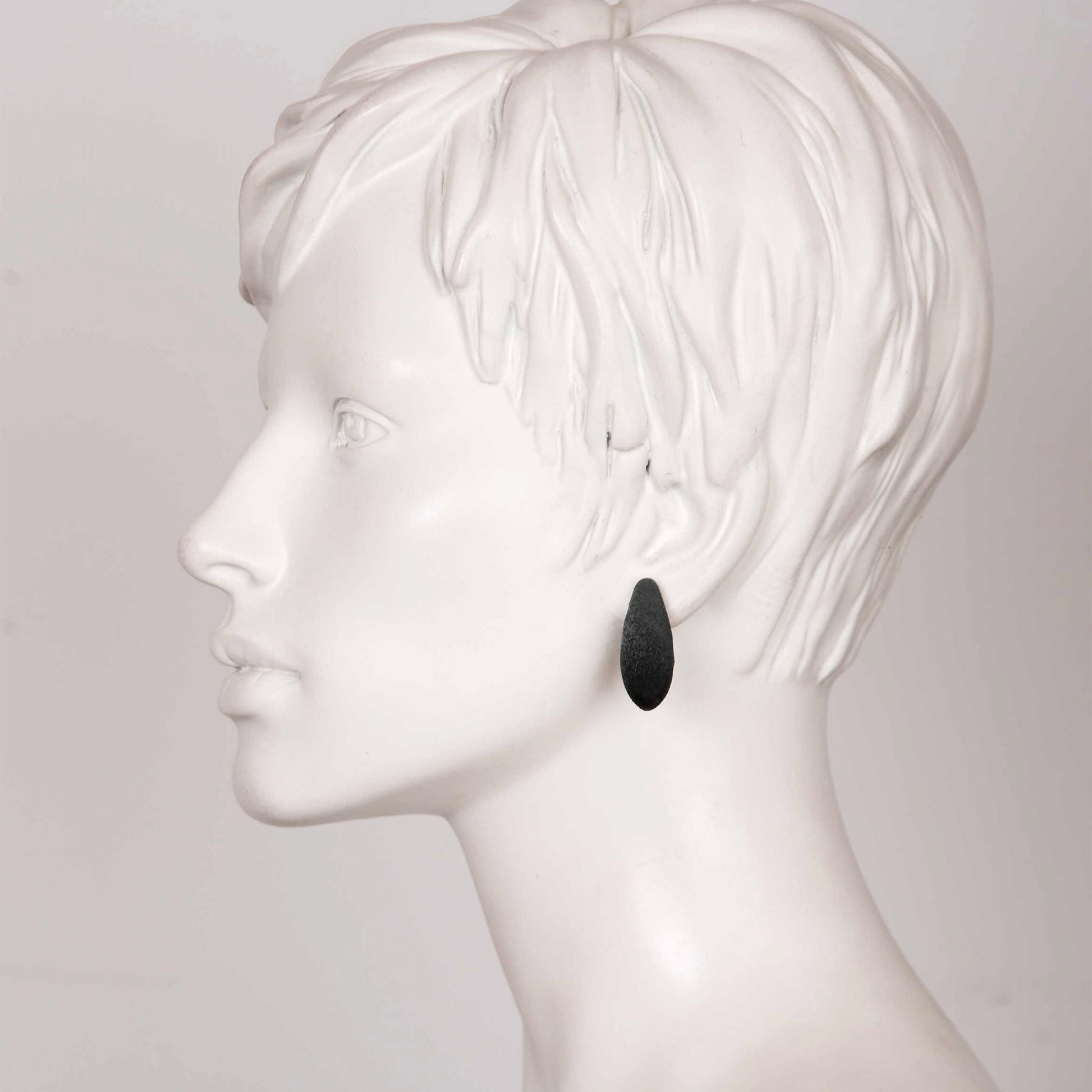bold close-up of elegant mini blackcurrant earrings with cosmic dust shimmer on a dark background