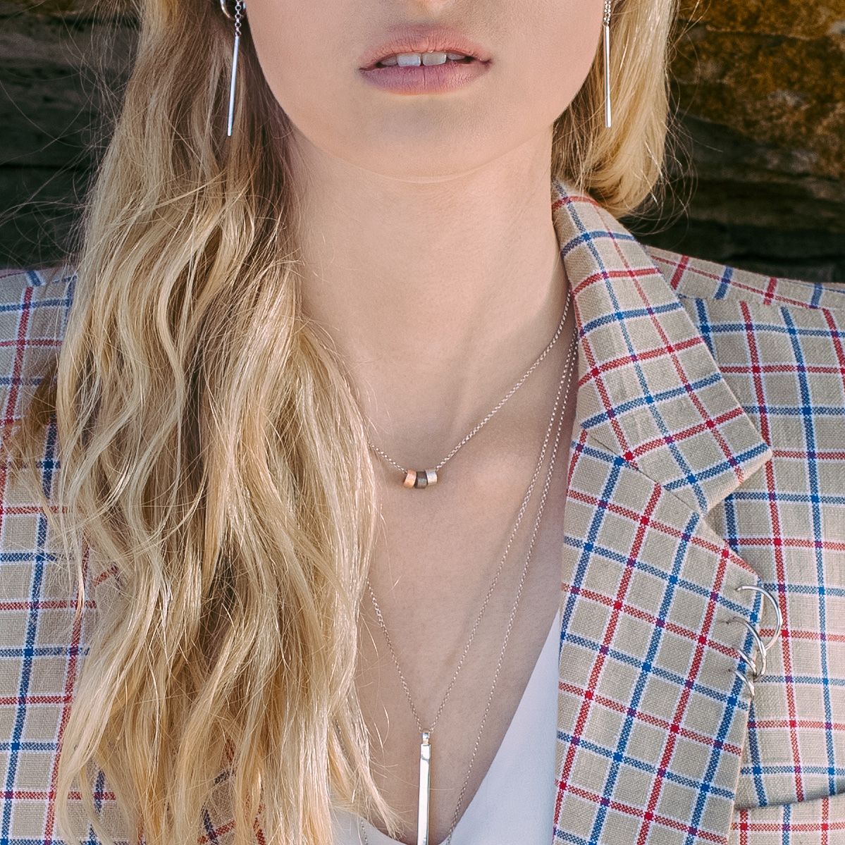 bold close-up of a sleek silverbar necklace on a dark background, radiating modern confidence