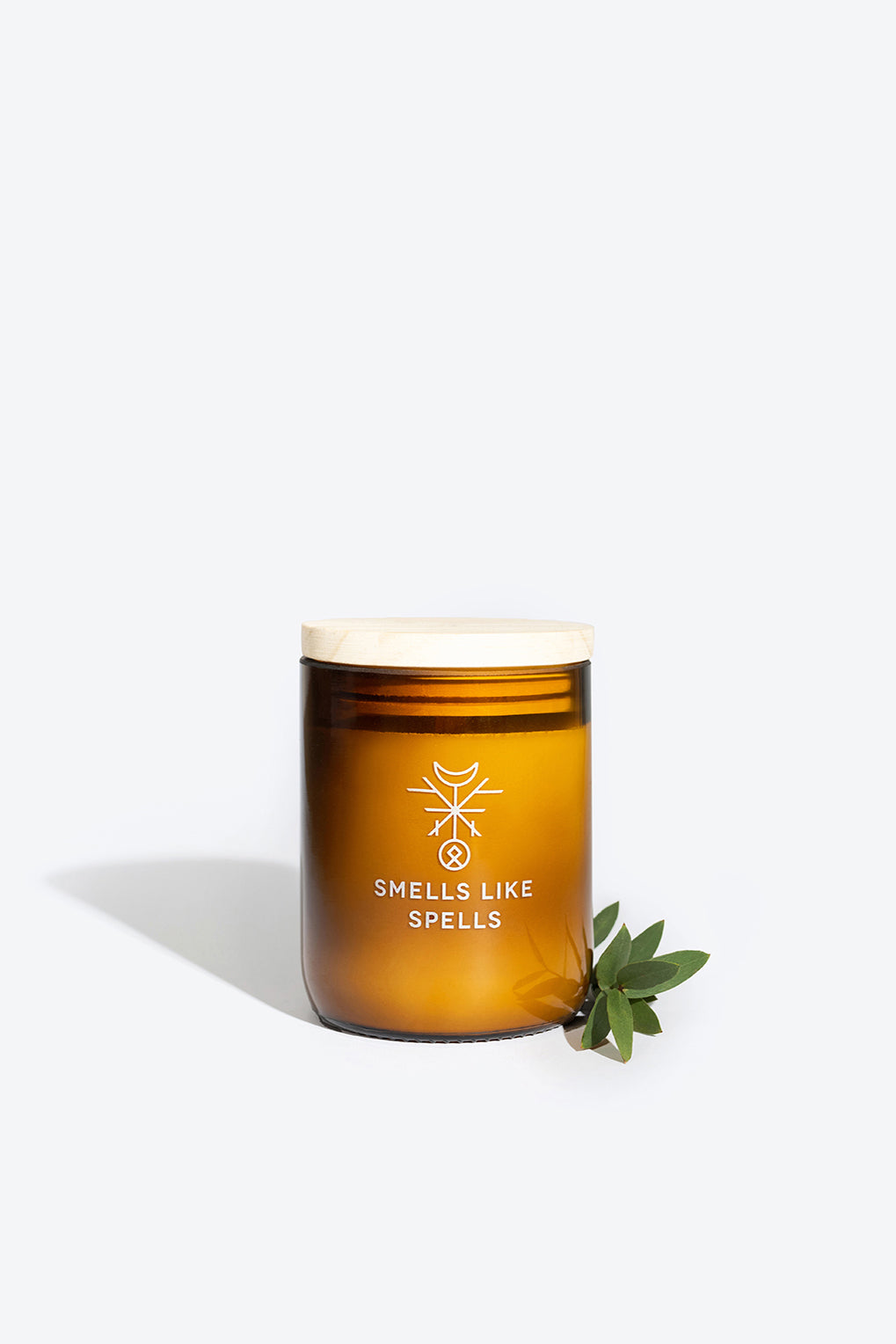 kvasir scented candle glowing boldly with its wooden wick and amber glass jar
