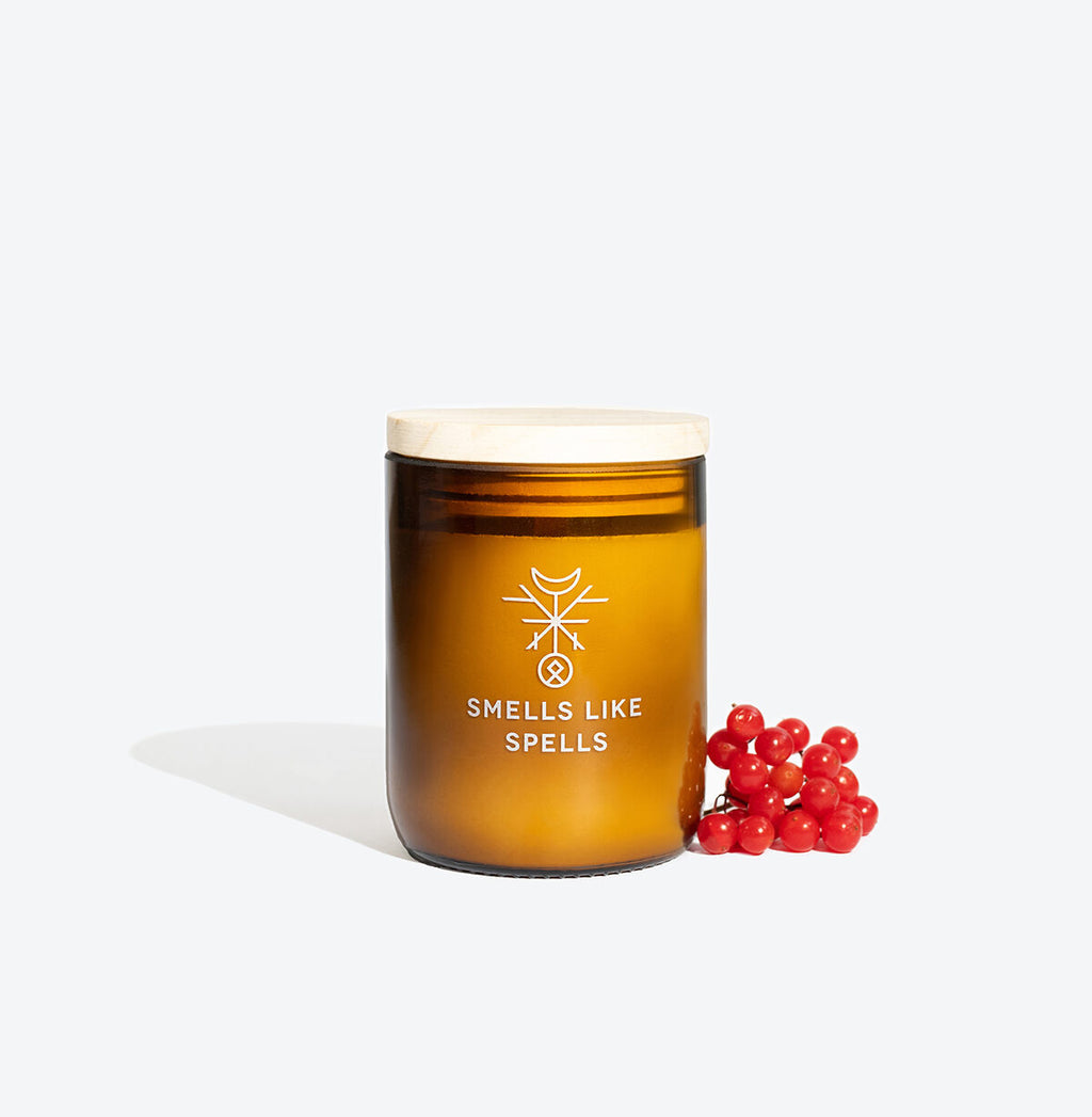 bold odin scented candle in amber jar with glowing wick, radiating strength and confidence