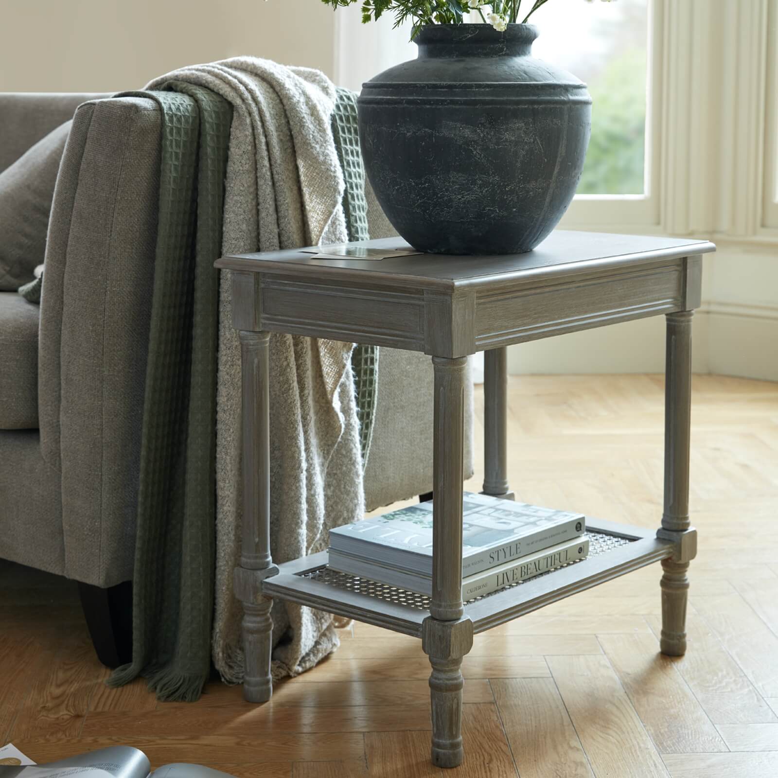 Handwoven rattan side table with tapered legs in soft grey, 60cm height, modern organic texture for coastal or minimalist decor by RoomLondon at brixbailey.com