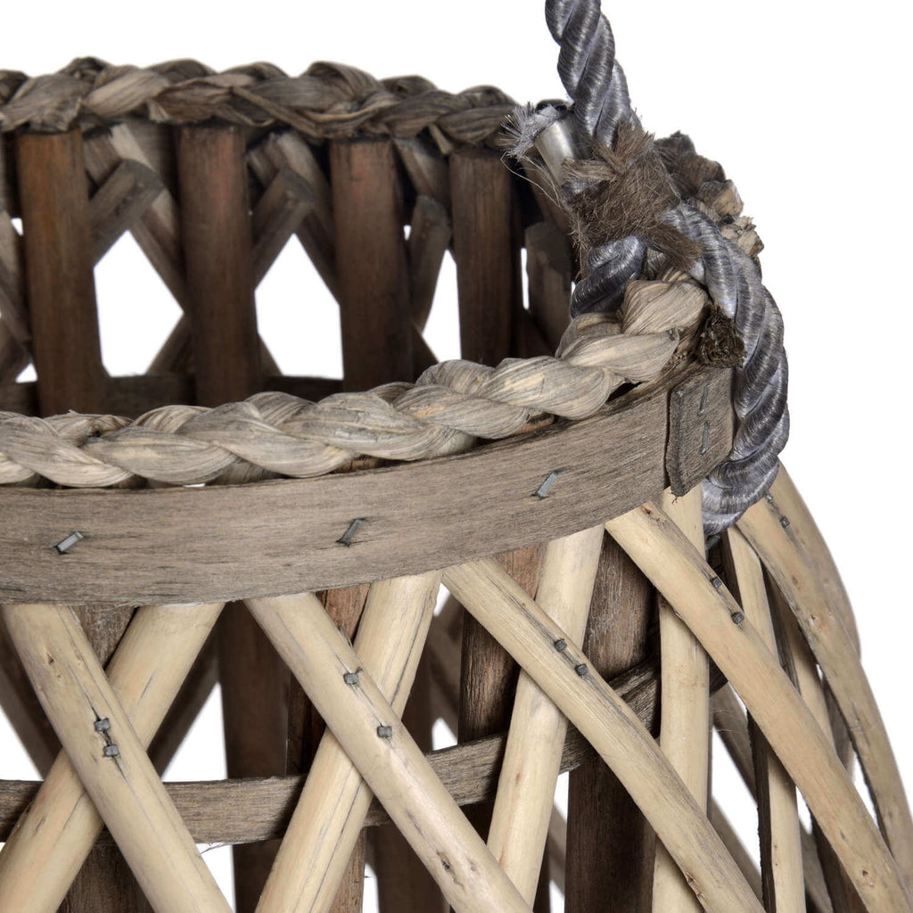 Handwoven rattan lantern with warm brown tones, creating enchanting light patterns for indoor or outdoor decor. by sostter at brixbailey.com