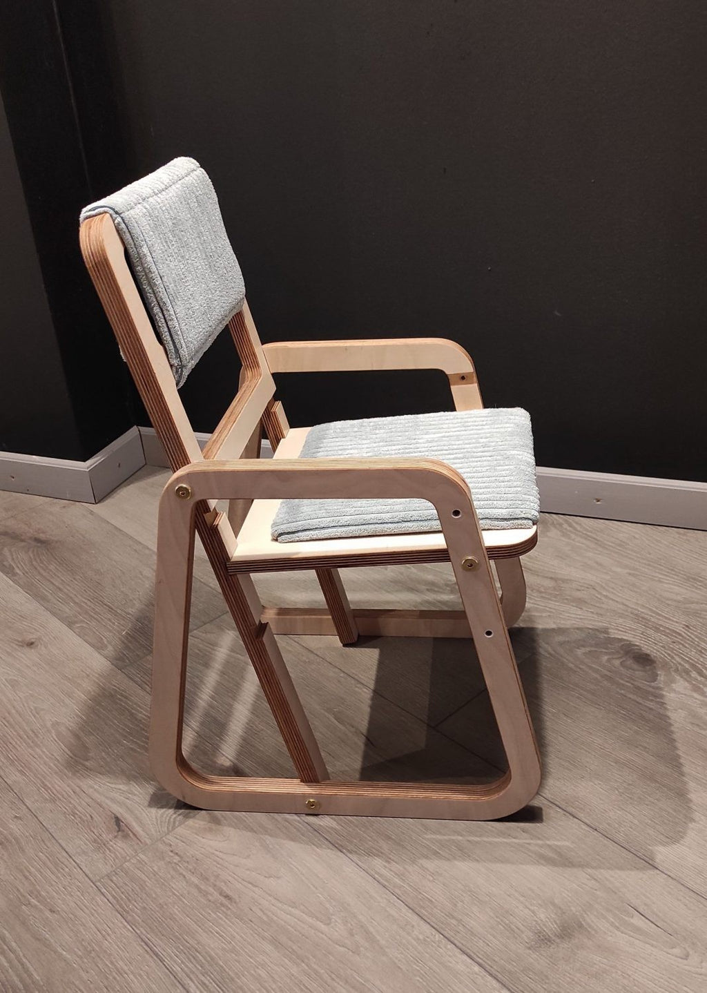 mint green julle kids chair in a bright playroom with morning light highlighting its smooth birch wood grain
