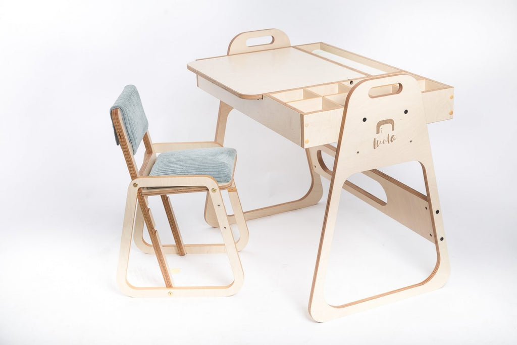 mint green kids art table with chalkboard and paper roll in a bright, sunlit playroom