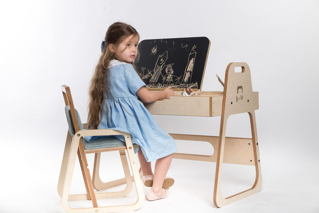 mint green kids art table with chalkboard and paper roll in a bright, sunlit playroom