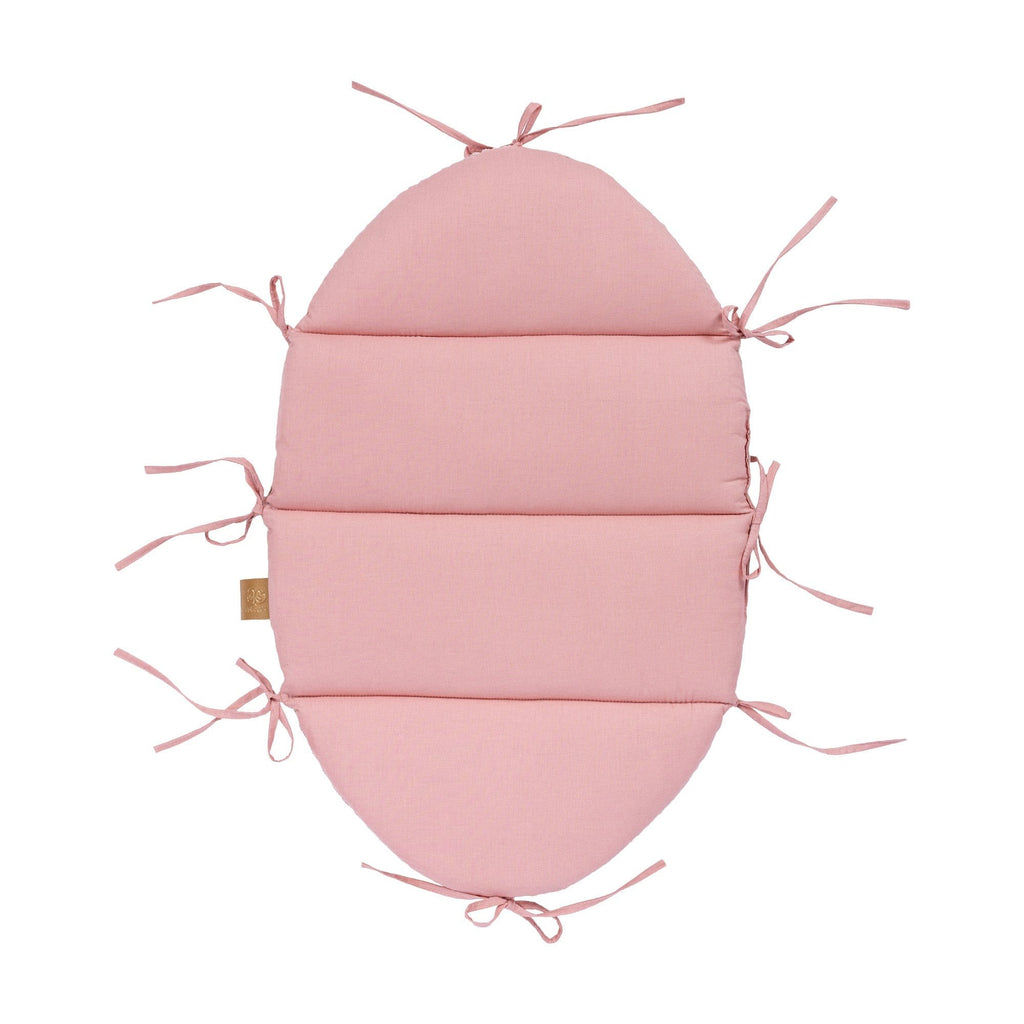 elegant powder pink baby nest with soft corduroy braid in a refined nursery setting