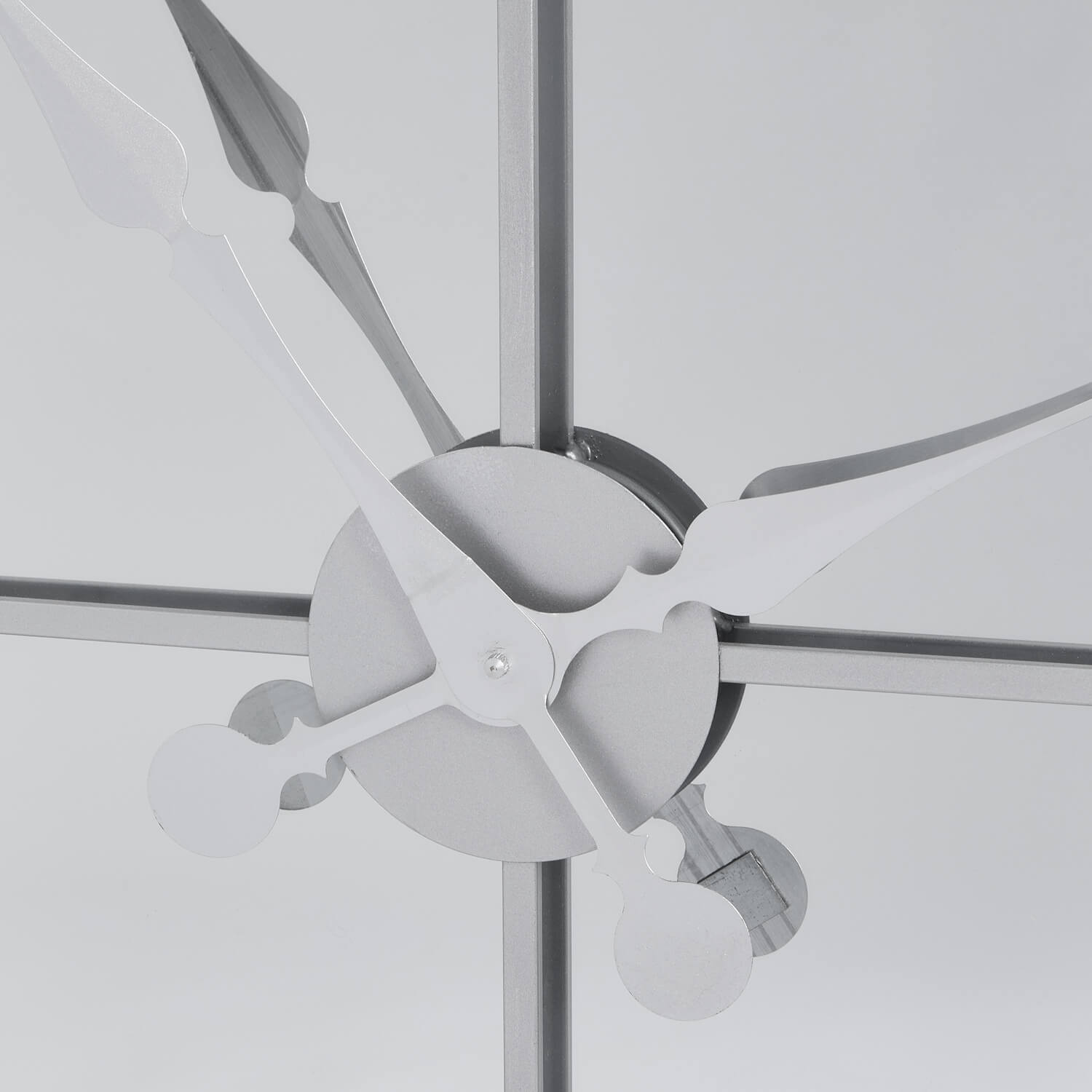 Celina mirrored wall clock with silver metal frame, modern skeleton design, and reflective glass surface by Sostter at brixbailey.com