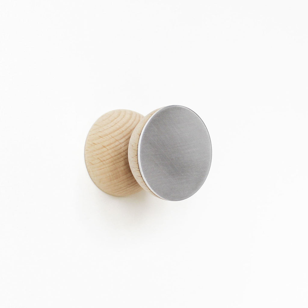 close-up of a modern beech wood and aluminium wall hook mounted on a cabinet