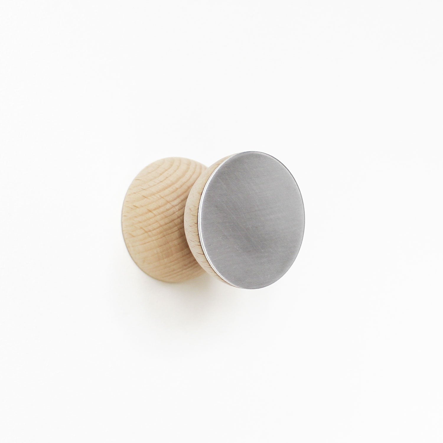 close-up of a modern beech wood and aluminium wall hook mounted on a cabinet