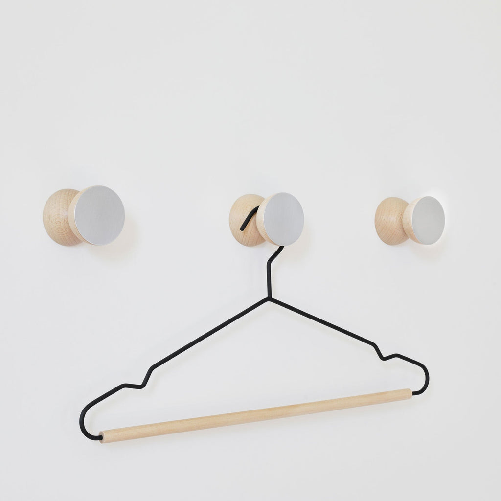 bold geometric wall hook in brushed aluminium and warm beech wood, a confident modern statement