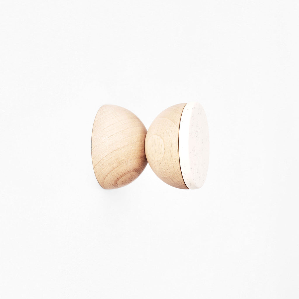 close-up of a white sand ceramic wall hook mounted on a cabinet