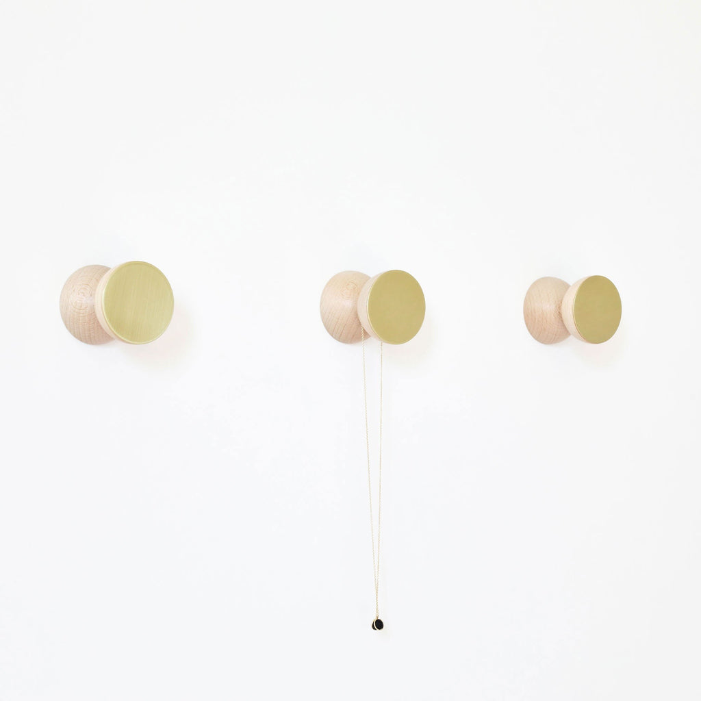 playful geometric beech wood and brass hook on a bright yellow wall