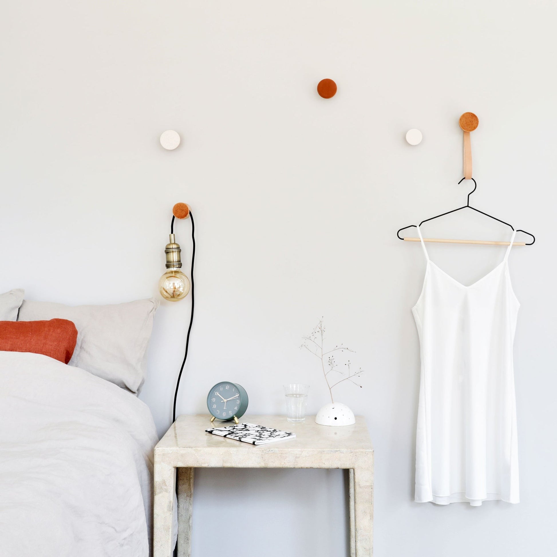 playful terracotta-speckled ceramic hook on beech wood, casting a fun shadow on a bright wall