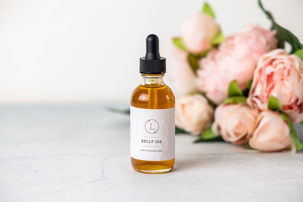 bold close-up of nourishing natural stretch mark belly oil bottle with golden amber glow
