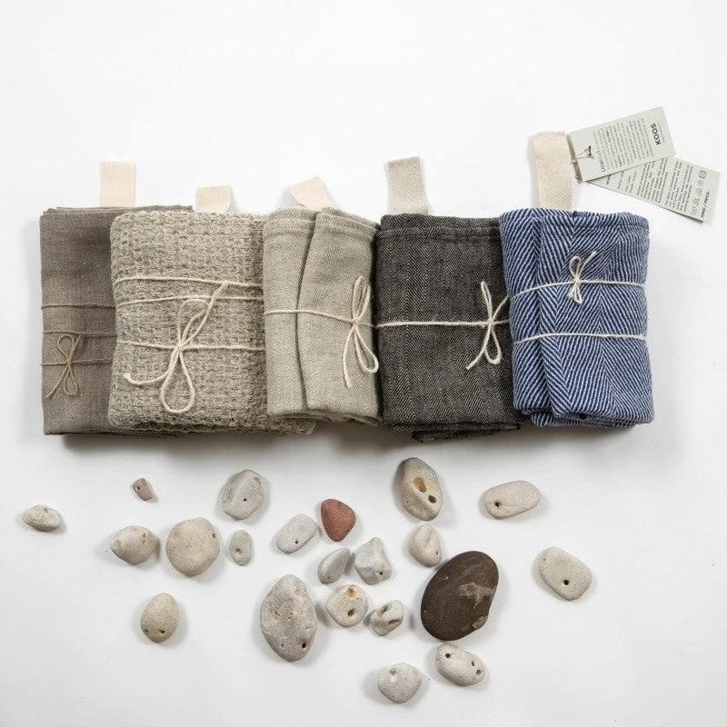 a practical grey linen bath towel folded neatly on a shelf