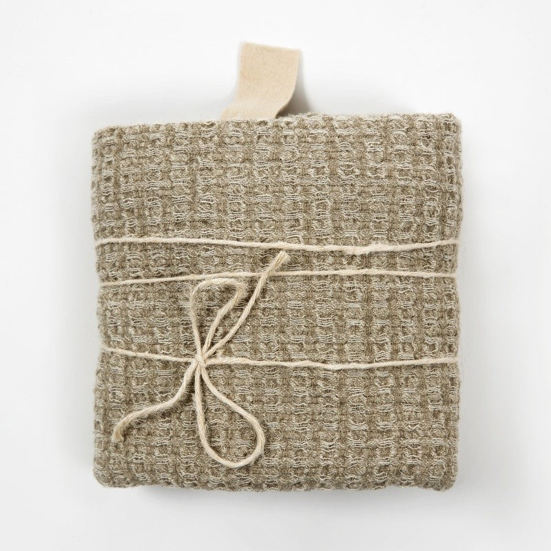 a soft grey linen bath towel draped gently, showcasing its comforting texture in warm, natural light
