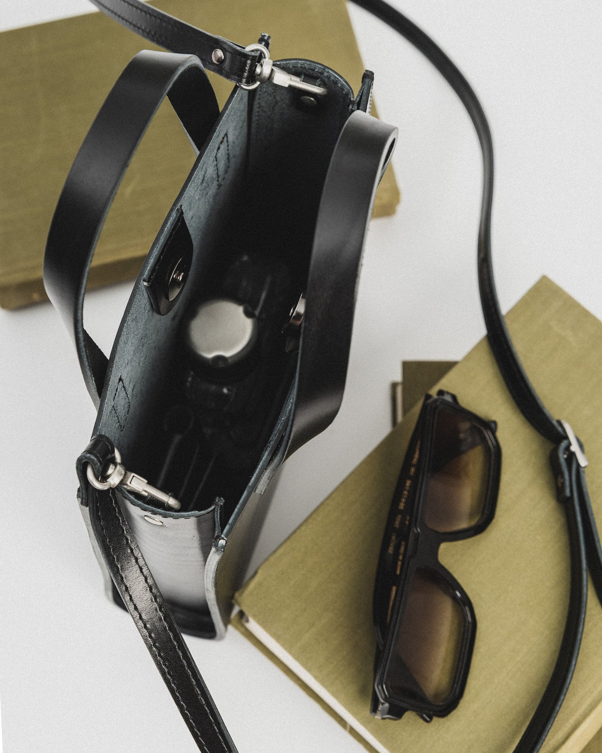 playful black bucket handbag worn crossbody on a sunny day