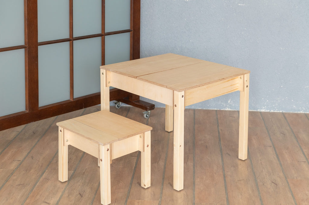 a playful toddler arranging crayons in the birch table's storage compartment