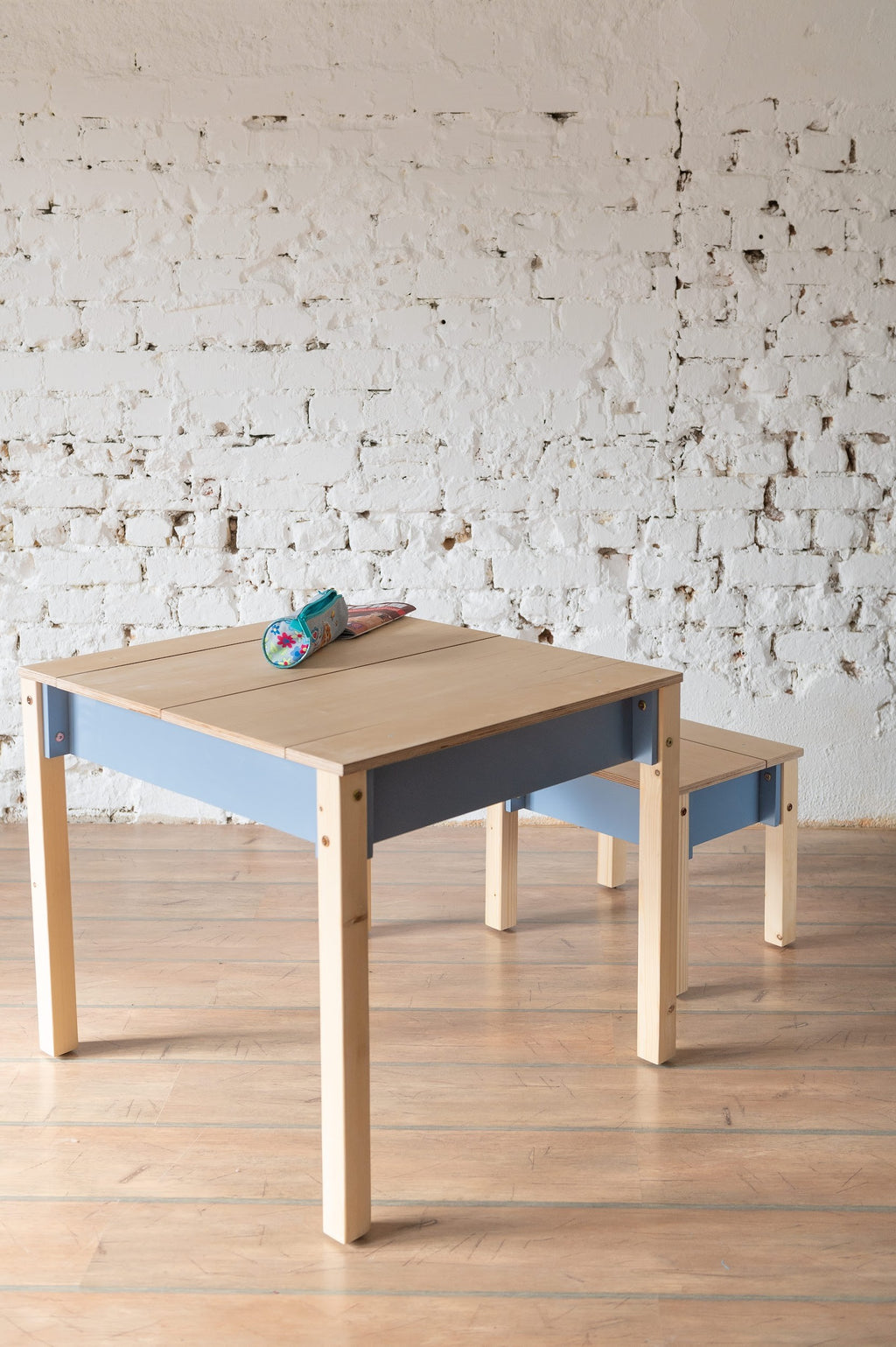 a child's compact birch chair with a hidden storage drawer open in a cozy room